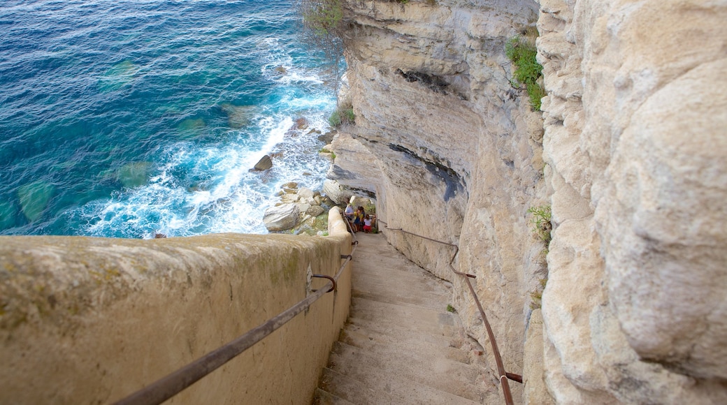 Escalier du Roi d\'Aragon showing hiking or walking and rocky coastline as well as a family