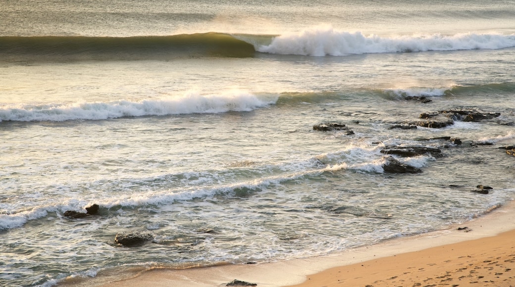 Jeffreys Bay mit einem Sonnenuntergang, Sandstrand und Brandung