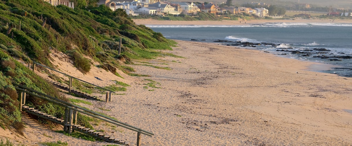 Jeffreys Bay showing rocky coastline, a sandy beach and general coastal views