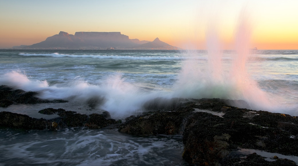 Bloubergstrand mit einem Sonnenuntergang, Berge und Felsküste