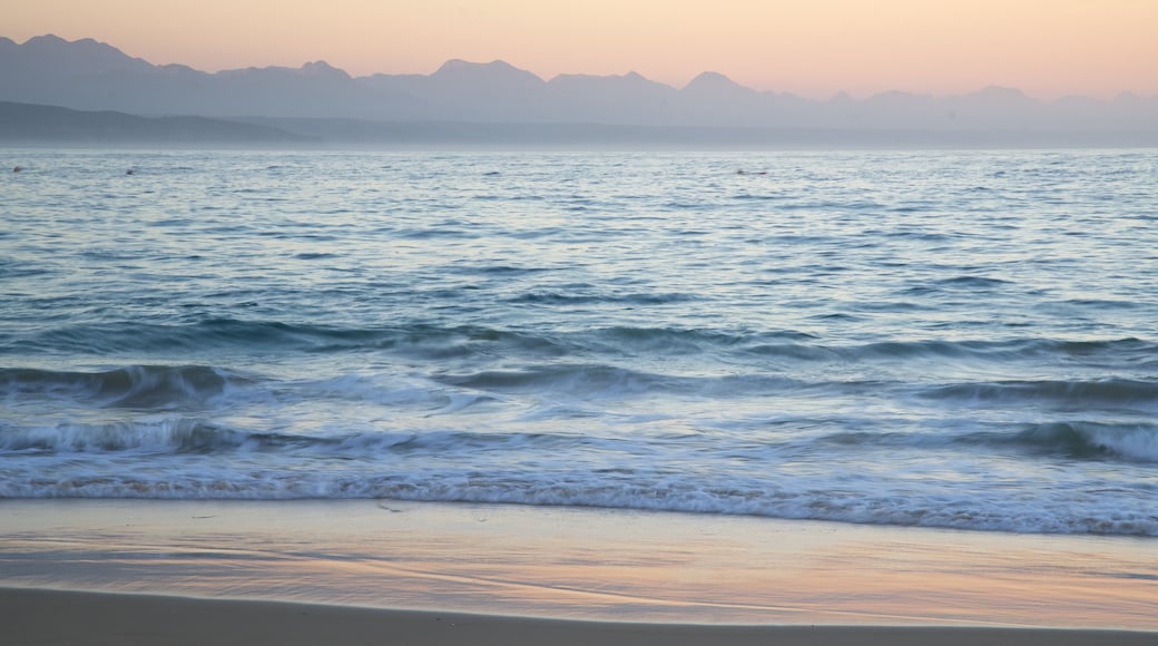 Playa de Plettenberg Bay que incluye vista general a la costa, una playa de arena y un atardecer