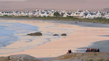 Paternoster Beach som inkluderar en kuststad, en solnedgång och kustutsikter