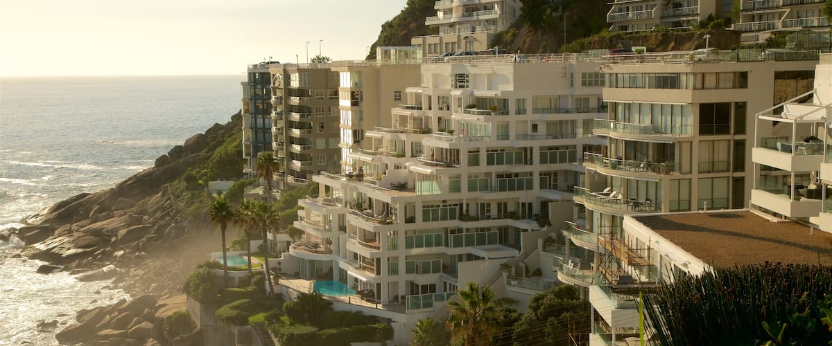 Clifton Bay Beach showing rugged coastline, a hotel and waves