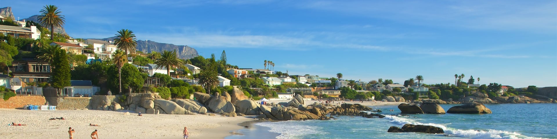 Clifton Bay Beach showing a coastal town, rocky coastline and a sandy beach