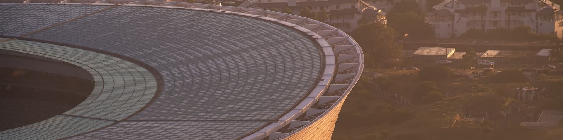 Cape Town Stadium featuring a sunset and a city