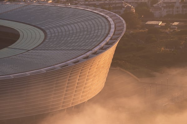 Cape Town Stadium featuring a sunset and a city