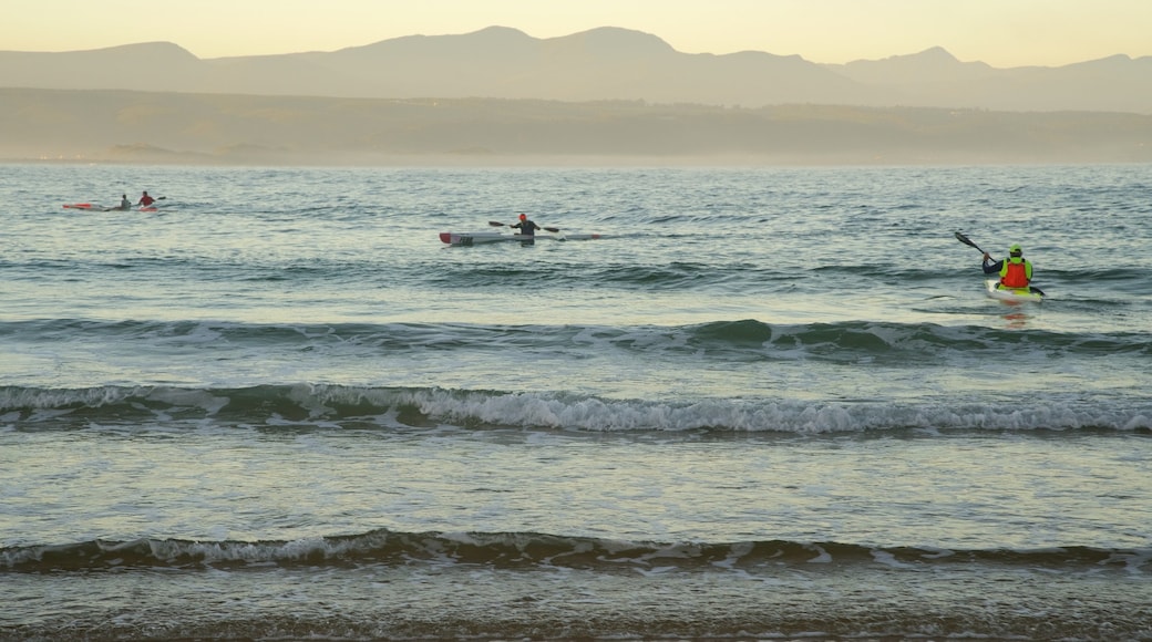 Playa de Plettenberg Bay que incluye una playa de arena y kayak o canoa y también un pequeño grupo de personas