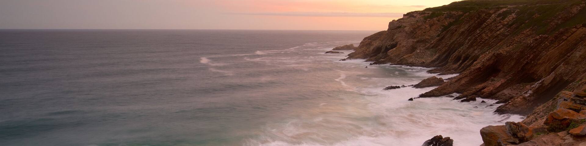 Cape St Blaize Cave showing rugged coastline, landscape views and a sunset