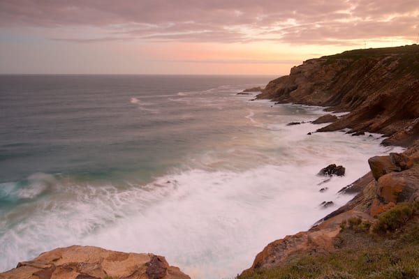 Cape St Blaize Cave which includes landscape views, rocky coastline and a sunset