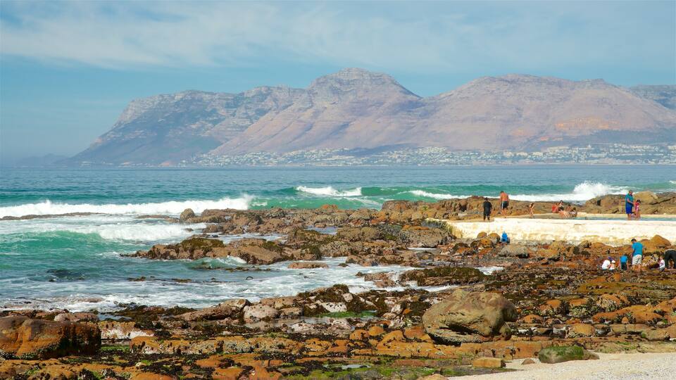 St. James mostrando litoral rocoso y vistas de una costa y también un grupo pequeño de personas