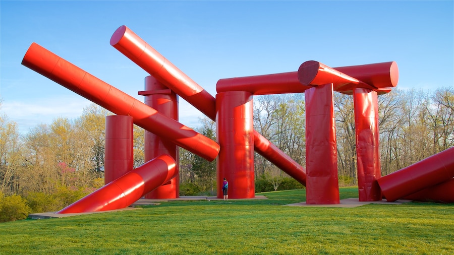 Laumeier Sculpture Park featuring a garden and outdoor art as well as an individual femail