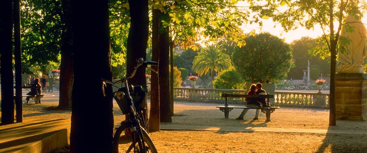 Luxembourg Gardens featuring a sunset and a garden as well as a couple