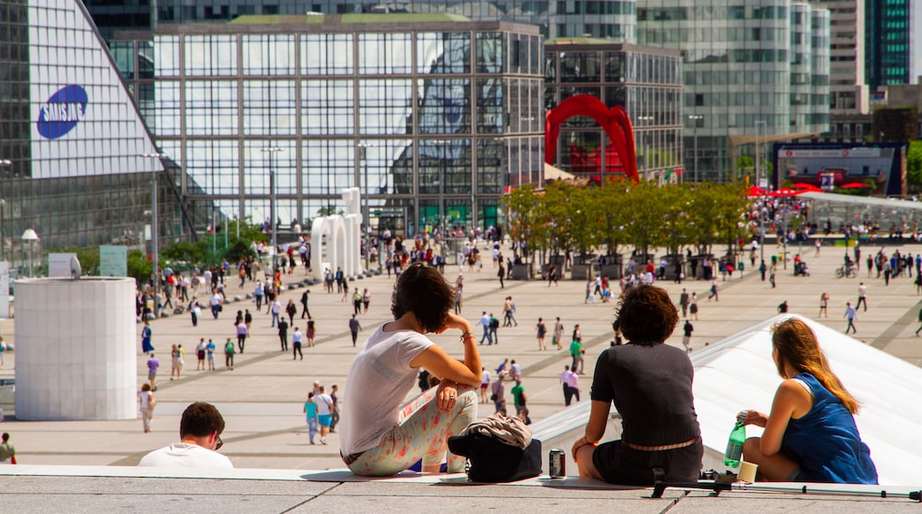 La Defense featuring a city and a square or plaza as well as a small group of people