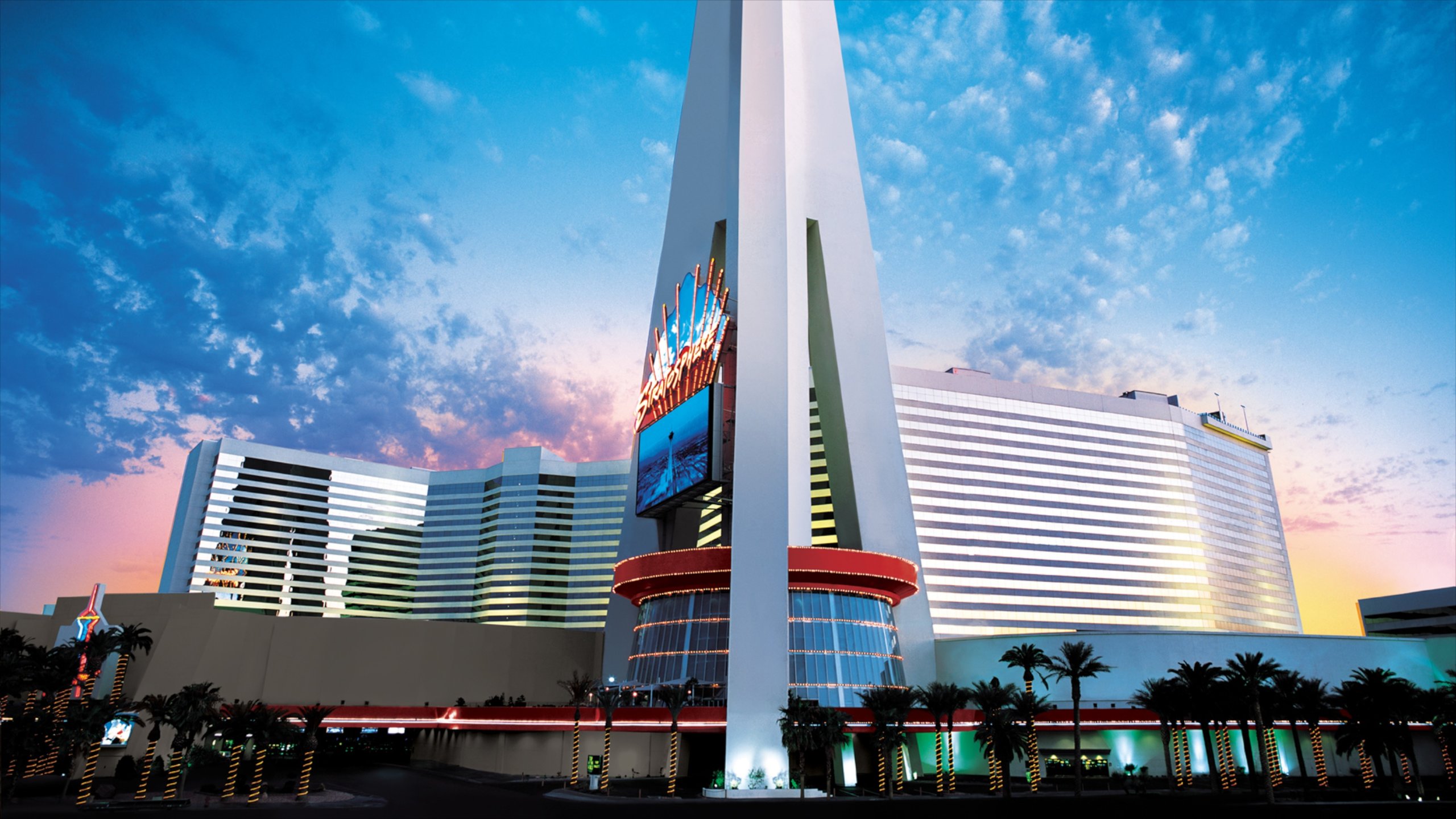 Torre Stratosphere mostrando un atardecer, un edificio alto y una ciudad