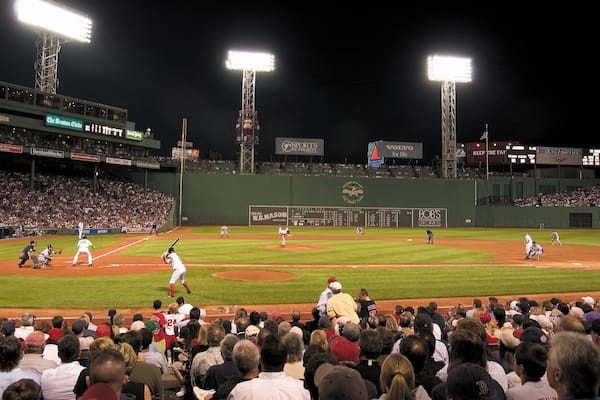 Estadio de béisbol Fenway Park mostrando un evento deportivo y escenas nocturnas y también un grupo grande de personas