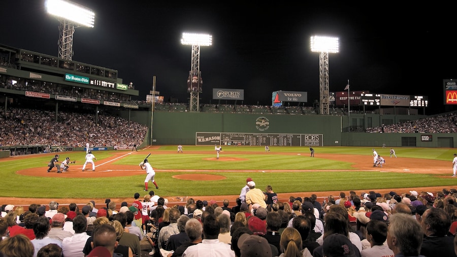 Fenway Park which includes a sporting event and night scenes as well as a large group of people