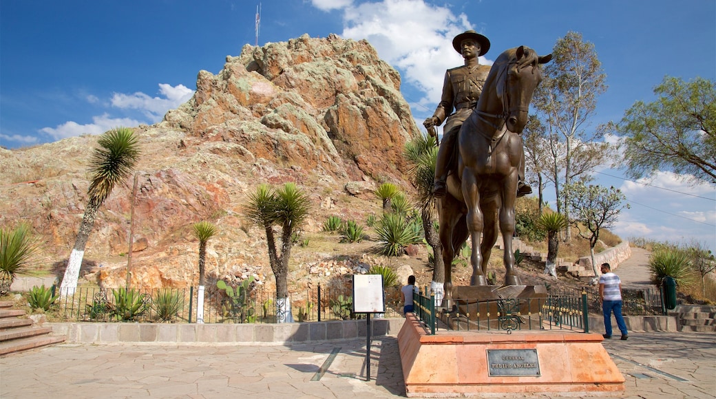 Mexico og byder på en statue eller en skulptur, bjerge og en plads eller et torv