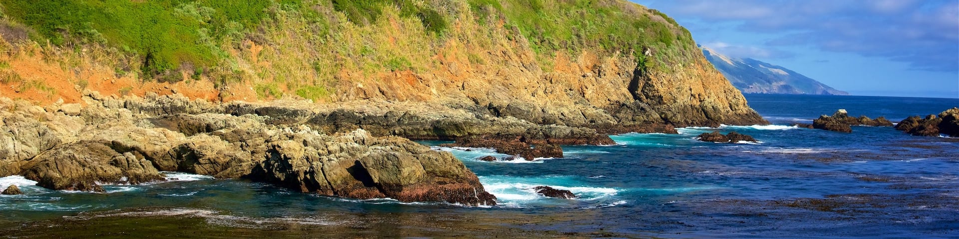 Cala Partington mostrando costa rocosa y montañas