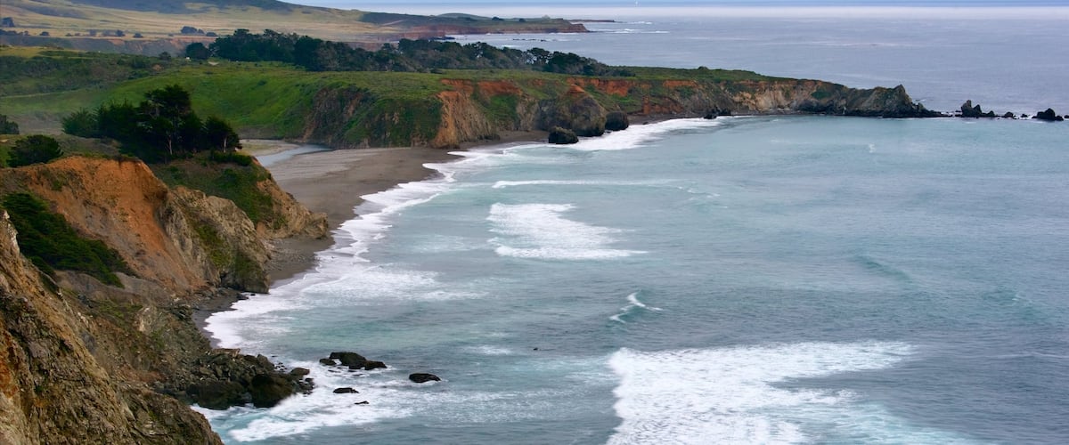 Ragged Point which includes rugged coastline, a bay or harbour and landscape views