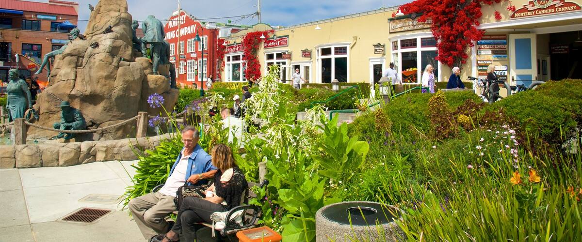 Cannery Row que incluye una estatua o escultura y un parque o plaza y también una pareja