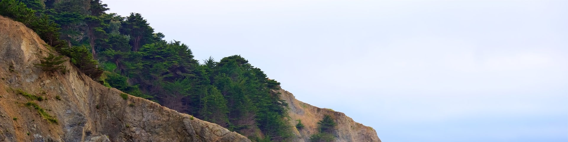 Playa China que incluye costa rocosa y vistas generales de la costa