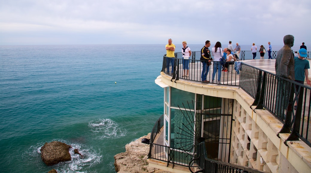 Balcón de Europa que incluye vista general a la costa y vista y también un gran grupo de personas