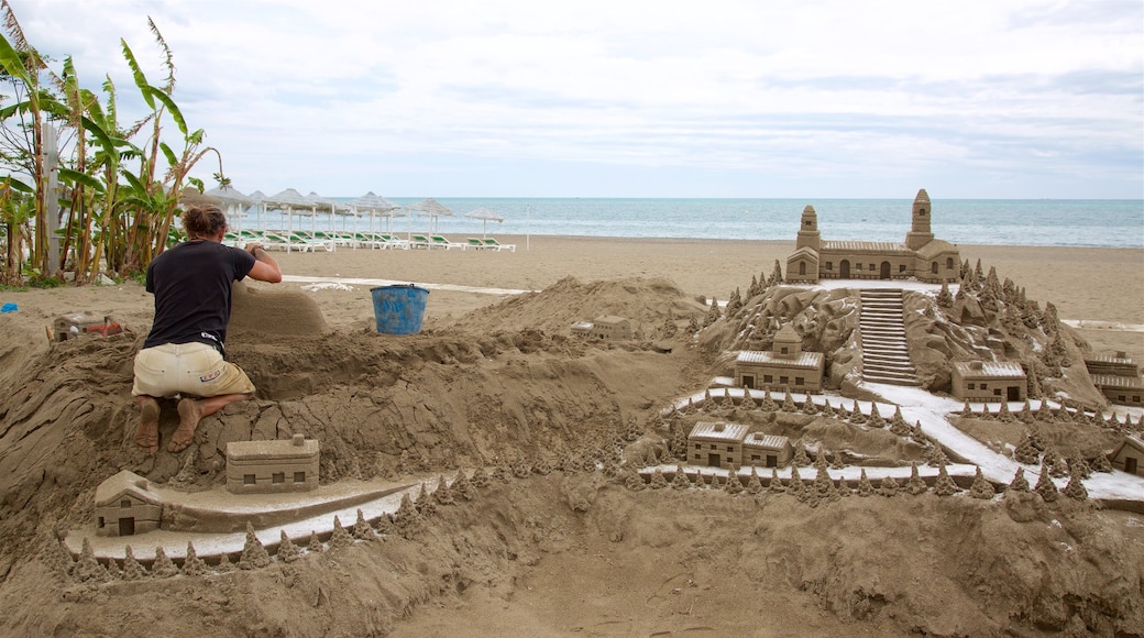 Torremolinos showing a sandy beach and outdoor art as well as an individual male