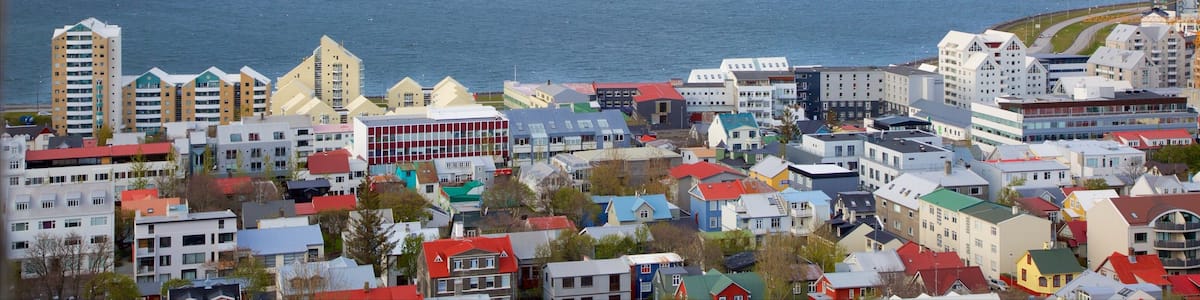 Reykjavík welches beinhaltet allgemeine Küstenansicht, Berge und Stadt
