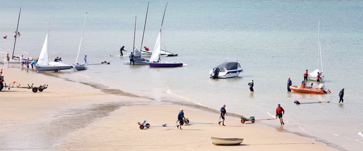 Tenby ofreciendo una playa de arena, una bahía o puerto y paseos en lancha