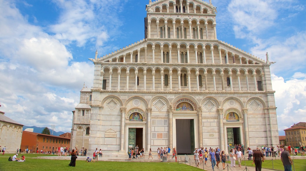 Catedral de Pisa que incluye una iglesia o catedral y arquitectura patrimonial y también un grupo grande de personas