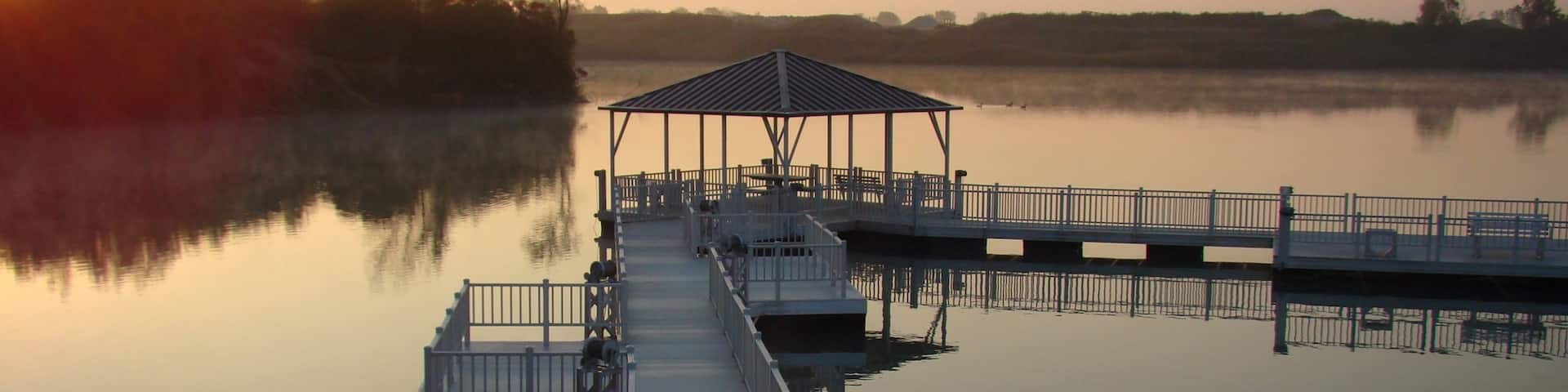 Champaign featuring a lake or waterhole and a sunset