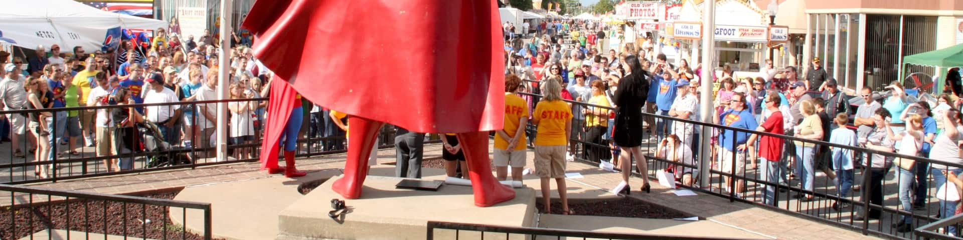 Superman Statue featuring a statue or sculpture as well as a large group of people