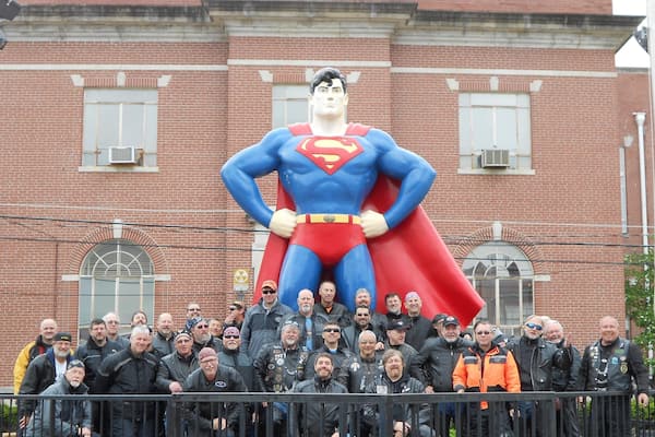 Superman Statue montrant statue ou sculpture aussi bien que petit groupe de personnes