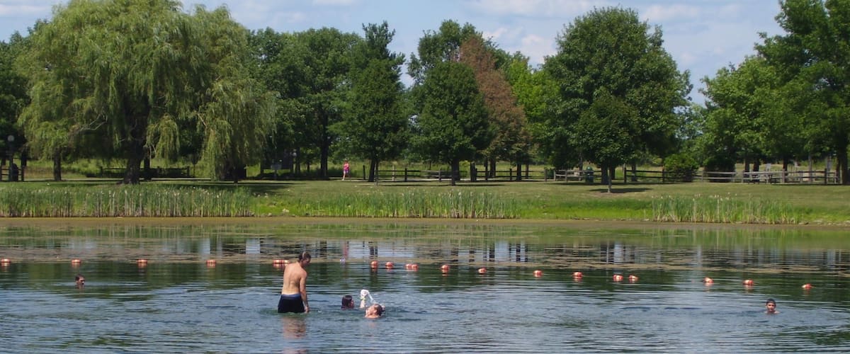 Champaign que incluye un lago o abrevadero y también un pequeño grupo de personas