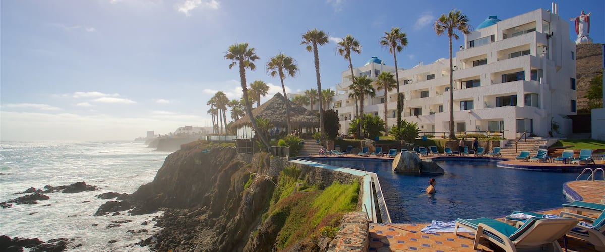 Rosarito que incluye un hotel o resort de lujo, una alberca y costa rocosa