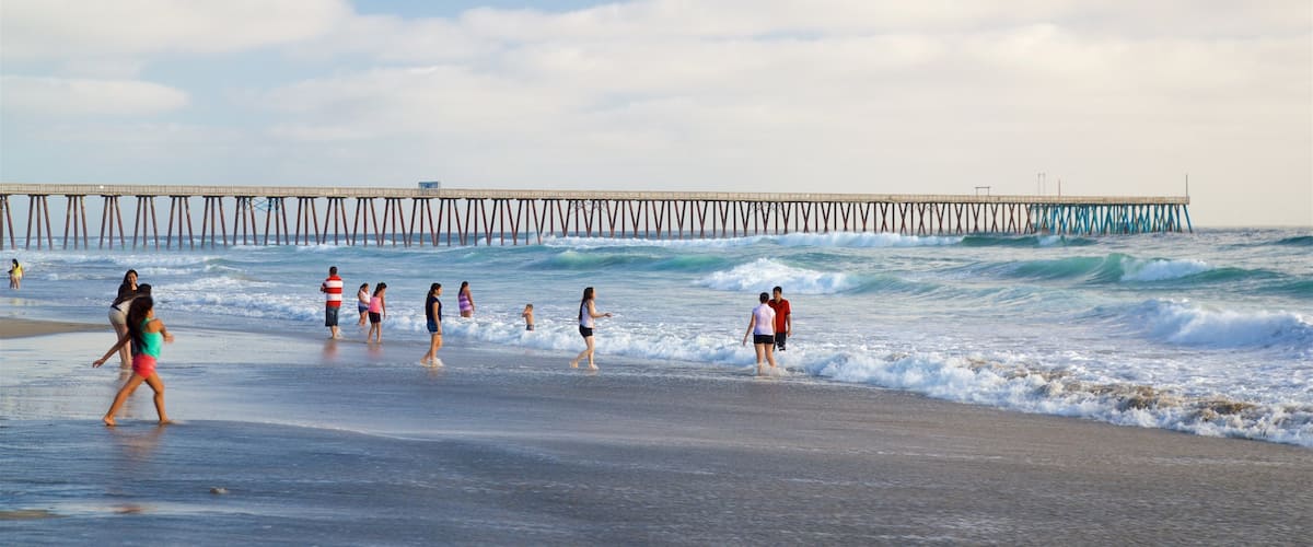 Rosarito mostrando surf y una playa de arena