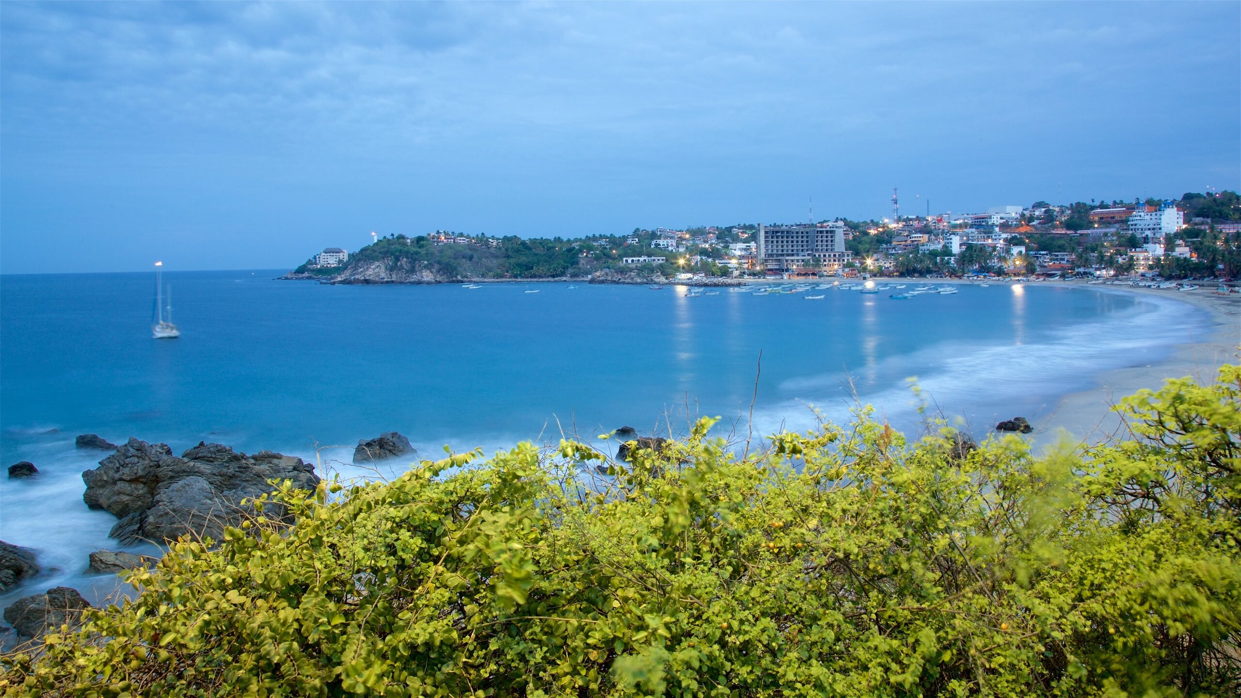 Oaxaca showing boating, rugged coastline and a beach