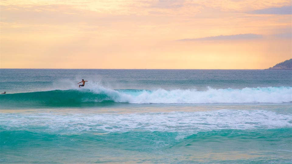 Zicatela Beach ofreciendo surf, un atardecer y olas