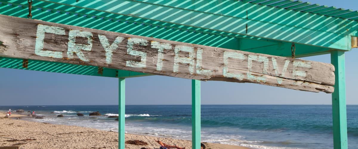 Crystal Cove State Park showing a beach, signage and landscape views
