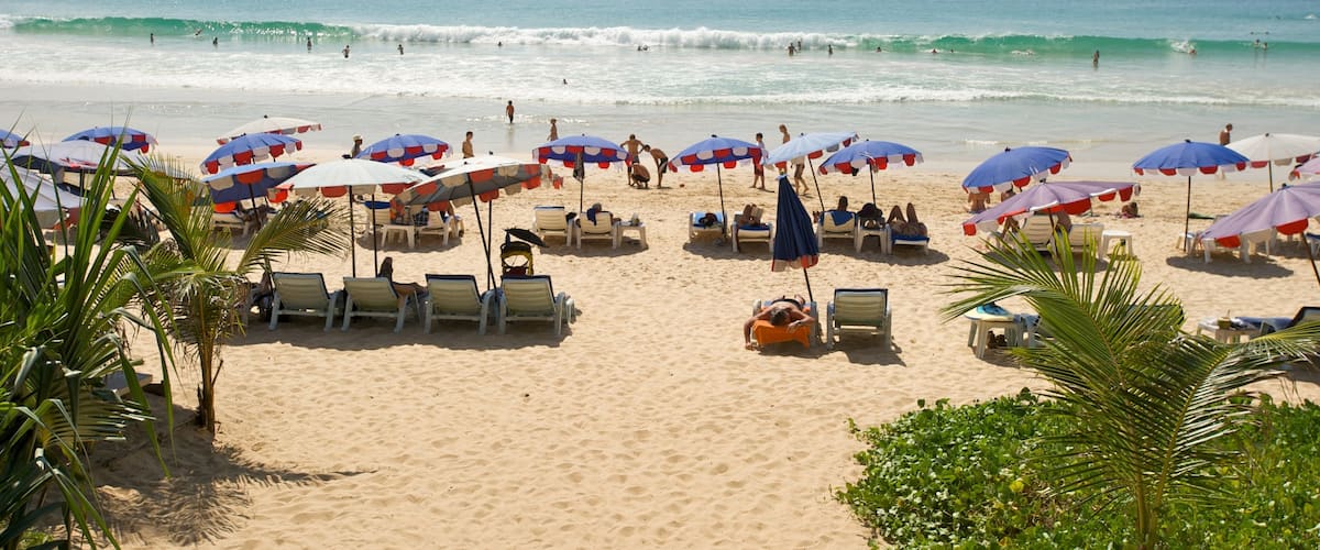 Playa Nai Harn mostrando escenas tropicales, natación y una playa de arena