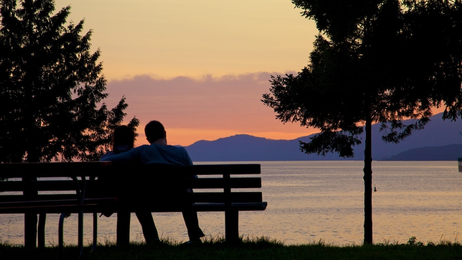 Couple sitting on a bench overlooking a sunset at Stanley Park in Vancouver, British Columbia.