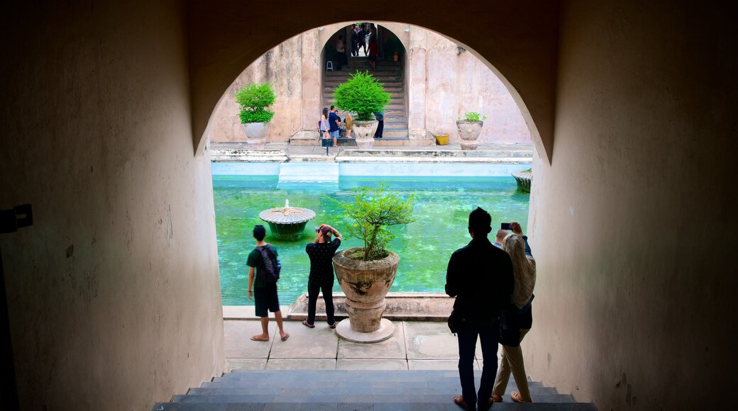 Water Castle which includes a pool and heritage architecture as well as a small group of people