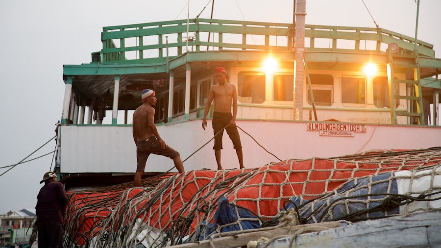 Sunda Kelapa which includes a bay or harbor and boating as well as a small group of people