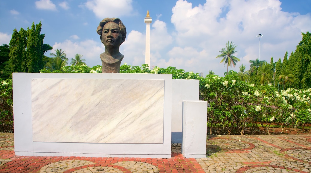 Praça Merdeka caracterizando uma estátua ou escultura e um parque