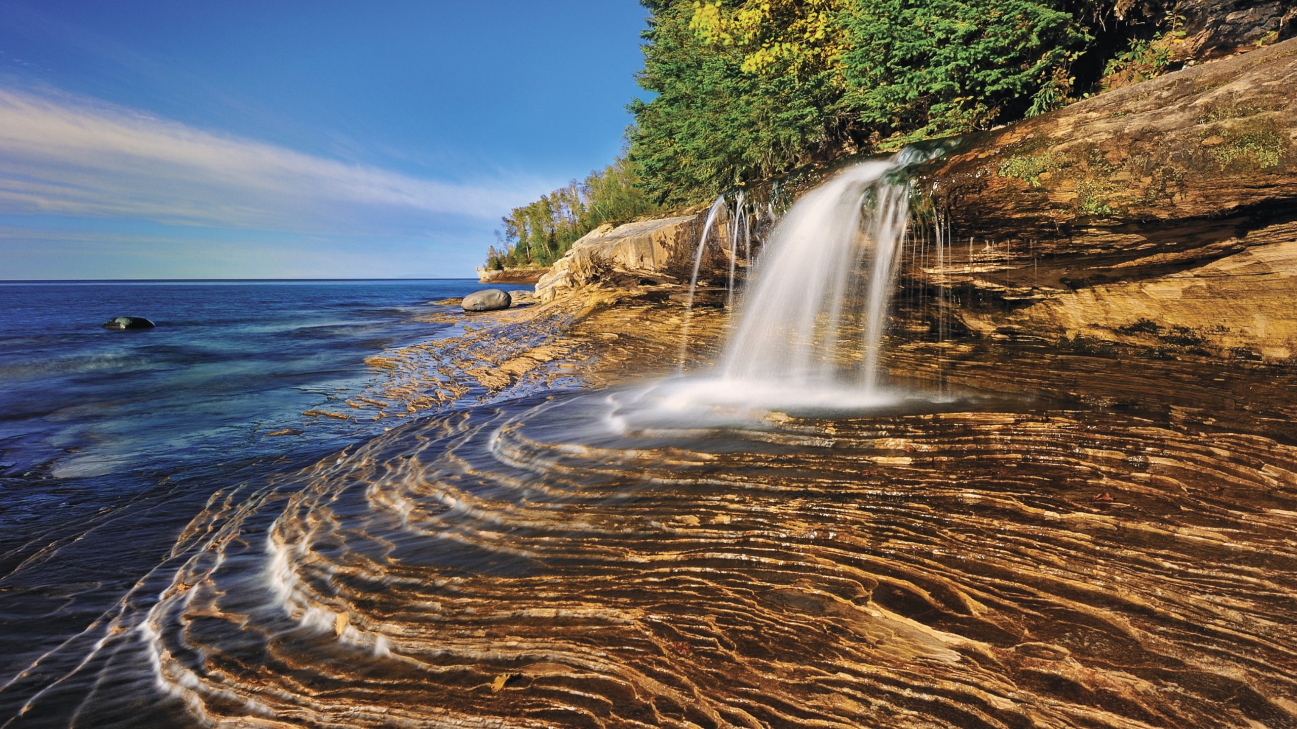 Munising que incluye litoral rocoso y una cascada