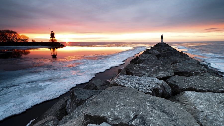 Alpena toont een meer of poel, een vuurtoren en een zonsondergang