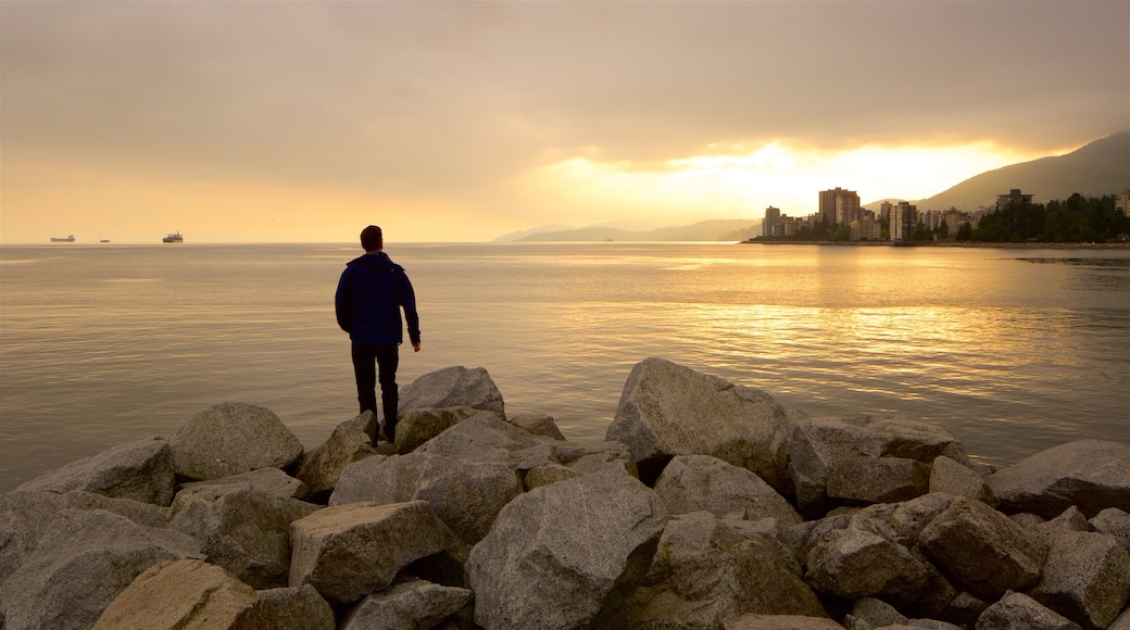 Ambleside Park som viser solnedgang og innsjø i tillegg til en mann