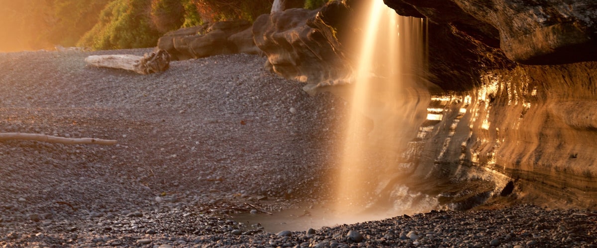 Sandcut Beach which includes a sunset and a pebble beach