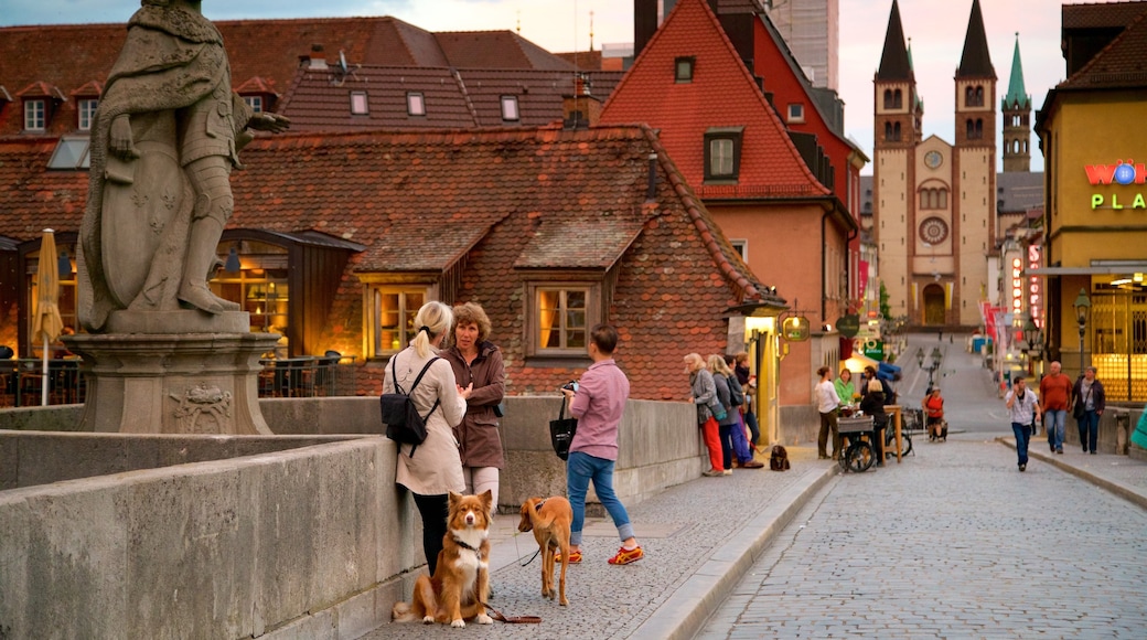 Alte Mainbruecke which includes heritage elements and a statue or sculpture as well as a small group of people