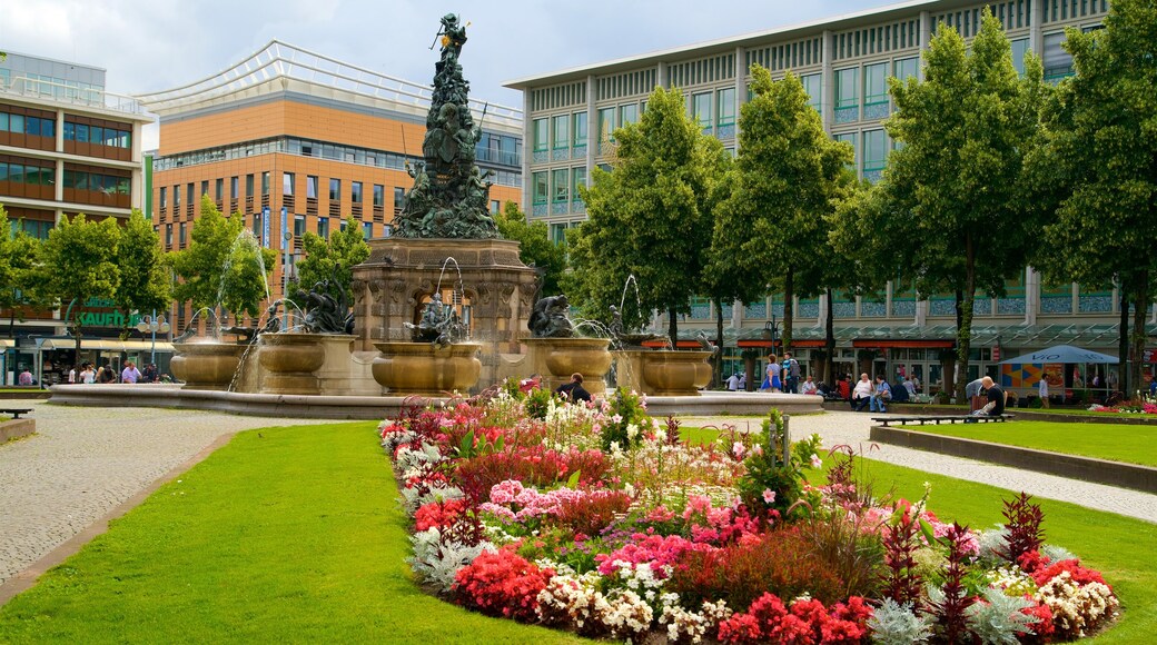 Mannheim som visar blommor, en park och en staty eller skulptur